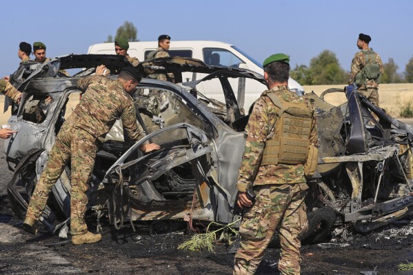 Lebanese army soldiers inspect a charred car that was hit by an Israeli strike, in the southern coastal town of Ghazieh, Lebanon, Friday, April 18, 2025. (AP Photo/Mohammed Zaatari)