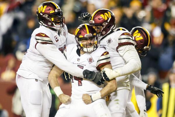 Washington Commanders quarterback Sam Howell (14) celebrates with teammates after his rushing touchdown during the second half of an NFL football game against the Dallas Cowboys, Sunday, Jan. 8, 2023, in Landover, Md. (Shaban Athuman/Richmond Times-Dispatch via AP)