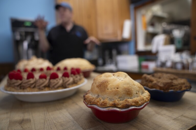 Manager Stephen Jarrett prepares pies on a counter at Michele's Pies, Wednesday, March 13, 2024, in Norwalk, Conn. (AP Photo/John Minchillo)