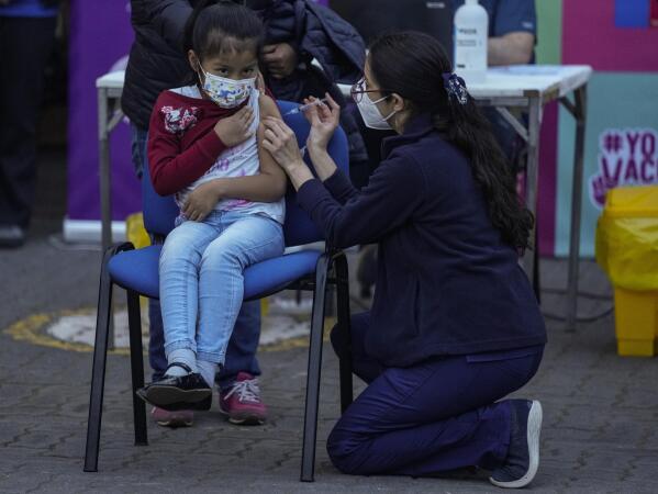 Un trabajador de la salud inocula a una niña contra el COVID-19 en la escuela Providencia en Santiago, Chile, el lunes 27 de septiembre de 2021, durante el inicio de la vacunación en escuelas para niños de 6 a 11 años. (AP Foto/Esteban Felix)