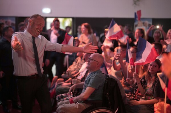 Local far-right mayor Steeve Briois, left, reacts after the release of projections based on the actual vote count in select constituencies, Sunday, June 30, 2024 in Henin-Beaumont, northern France. (AP Photo/Thibault Camus)