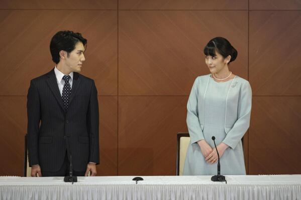Japan's former Princess Mako, right, the elder daughter of Crown Prince Akishino and Crown Princess Kiko, and her husband Kei Komuro, look at each other during a press conference to announce their marriage at a hotel in Tokyo, Japan Tuesday, Oct. 26, 2021. Former Princess Mako married the commoner and lost her royal status Tuesday in a union that has split public opinion after a three-year delay caused by a financial dispute involving her new mother-in-law. (Nicolas Datiche/Pool Photo via AP)