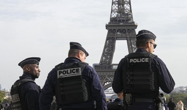 FILE - Police officers patrol the Trocadero plaza near the Eiffel Tower in Paris, Tuesday, Oct. 17, 2023. The French Interior Minister said Friday that security authorities have foiled a plan to attack soccer events during the Paris Olympics. Gerald Darmanin said in a statement Friday May 31, 2024 that an 18-year-old man from Chechnya was arrested on May 22 on suspicion of being behind a plan to attack soccer events that will be held in the city of Saint-Etienne, southwest of Lyon. (AP Photo/Michel Euler, File)