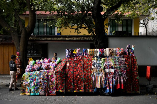FILE - A car covered with handicrafts for sale is parked on a street in Mexico City, Dec. 4, 2023. Mexican President Andres Manuel Lopez Obrador took office in 2018 with a motto that outlined his administration's priorities: 