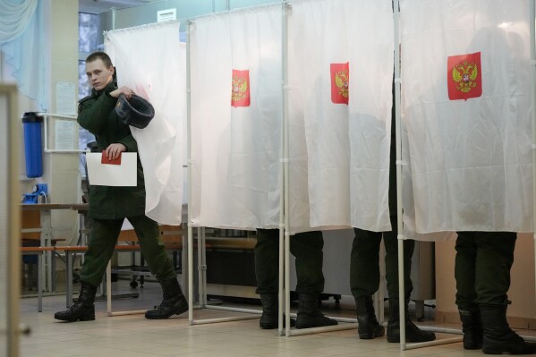 A Russian serviceman leaves a voting booth at a polling station during a presidential election in St. Petersburg, Russia, Friday, March 15, 2024. Voters in Russia headed to the polls for a presidential election that was all but certain to extend President Vladimir Putin's rule after he clamped down on dissent. (AP Photo/Dmitri Lovetsky)