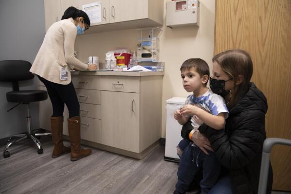 FILE - Ilana Diener holds her son, Hudson, 3, during an appointment for a Moderna COVID-19 vaccine trial in Commack, N.Y. on Nov. 30, 2021. On Thursday, April 28, 2022, Moderna asked U.S. regulators to authorize low doses of its COVID-19 vaccine for children younger than 6, a long-awaited move toward potentially opening shots for millions of tots by summer. (AP Photo/Emma H. Tobin, File)