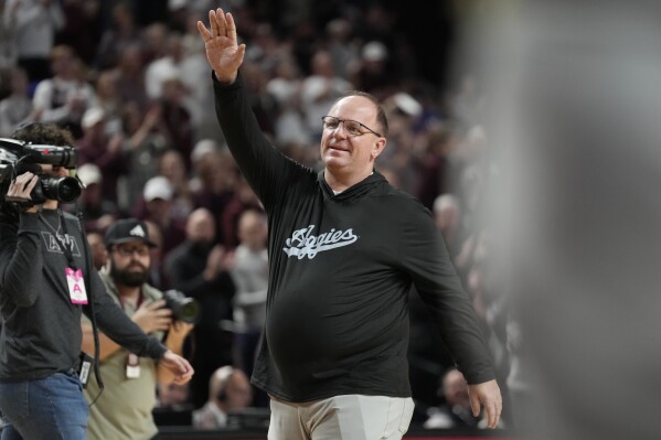 FILE - Texas A&M head football coach Mike Elko waves to the crowd at Reed arena during an NCAA college basketball game between Texas A&M and Kentucky on Saturday, Jan. 13, 2024, in College Station, Texas. The first full week for the upcoming college football season will feature a Saturday tripleheader on ABC, including Texas A&M hosting Notre Dame. ESPN announced its major matchups for Week 0 and Week 1 on Tuesday as part of its presentation to advertisers in New York. The Aug. 31 matchup marks Mike Elko’s first game as Texas A&M’s head coach. (AP Photo/Sam Craft, File)