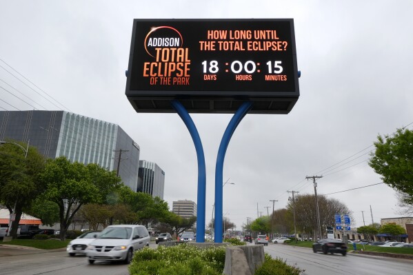 Information regarding the total solar eclipse is shown on a digital bill board as drivers make their way down a busy road in Addison, Texas, Thursday, March 21, 2024. (AP Photo/Tony Gutierrez)