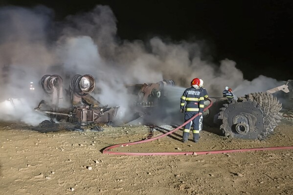 In this image released by Romania's Emergency Services, ISU Vrancea, firefighters work at the site of an explosion on a highway construction in the area of Calimanesti, eastern Romania, early Thursday, Sept. 21, 2023. A gas explosion in Romania early on Thursday killed four people and injured five, emergency authorities in the eastern European country said. (ISU Vrancea via AP)