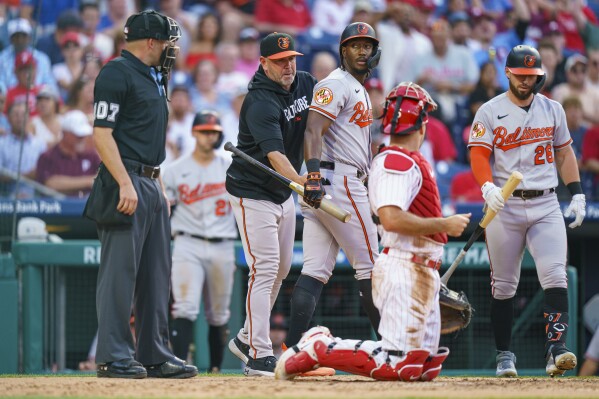 Baltimore Orioles' Jorge Mateo, center, gets escorted back to the dugout by manager Brandon Hayes, second from left, after arguing with umpire Dan Merzel, left, during the first inning of a baseball game against the Philadelphia Phillies, Wednesday, July 26, 2023, in Philadelphia. (AP Photo/Chris Szagola)