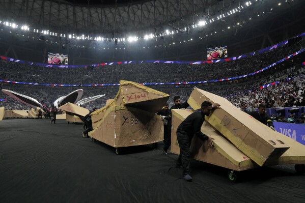 Migrant workers move away parts of the stage used during the opening ceremony ahead of the Asian Cup Group A soccer match between Qatar and Lebanon at Lusail Stadium in Lusail, Qatar, Friday, Jan. 12, 2024. The plight of migrant workers in Qatar came under the spotlight for more than decade after the gas-rich Middle Eastern emirate was awarded the APCup in 2010. Workers labored in the searing heat to build over $200 billion worth of stadiums and infrastructure that helped make the tournament such a success. (APPhoto/Aijaz Rahi)