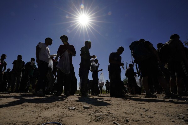 Migrants wait to be processed by the U.S. Customs and Border Patrol after they crossed the Rio Grande and entered the U.S. from Mexico, Thursday, Oct. 19, 2023, in Eagle Pass, Texas. (AP Photo/Eric Gay)