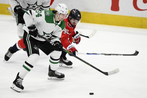 Dallas Stars right wing Denis Gurianov (34) skates with the puck against Washington Capitals left wing Marcus Johansson (90) during the third period of an NHL hockey game, Thursday, Dec. 15, 2022, in Washington. The Stars won 2-1. (AP Photo/Nick Wass)