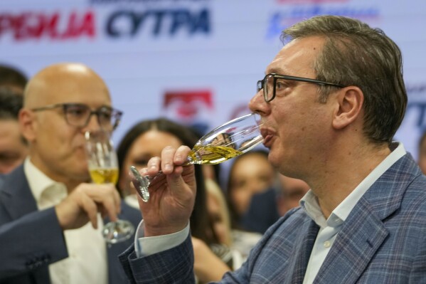El presidente serbio Aleksandar Vucic toma champaña después de declarar la victoria en las elecciones, en Belgrado, Serbia, el domingo 2 de junio de 2024. (AP Foto/Darko Vojinovic)