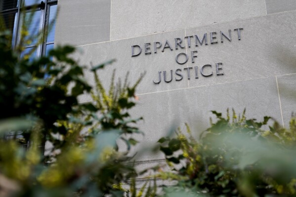 FILE - A sign marks an entrance to the Robert F. Kennedy Department of Justice Building in Washington, Jan. 23, 2023. The Justice Department proposed changes Monday, Feb. 5, 2024, to rules governing state-run programs that provide financial assistance to violent crime victims in order to address racial disparities and curb the number of subjective denials of compensation. (AP Photo/Patrick Semansky, File)