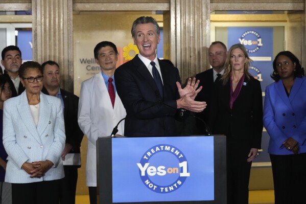 FILE - California Gov. Gavin Newsom speaks in support of Proposition 1, a $6.38 billion bond ballot measure, during a news conference at the Los Angeles General Medical Center in Los Angeles, Wednesday, Jan. 3, 2024. California voters have passed the measure that will impose strict requirements on counties to spend on housing and drug treatment programs to tackle the state’s homelessness crisis. Los Angeles Mayor Karen Bass listens at left. (AP Photo/Damian Dovarganes, File)