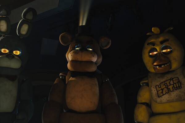This image released by Universal Pictures shows, from left, Bonnie, Freddy Fazbear and Chica in a scene "Five Nights at Freddy's." (Universal Pictures via AP)