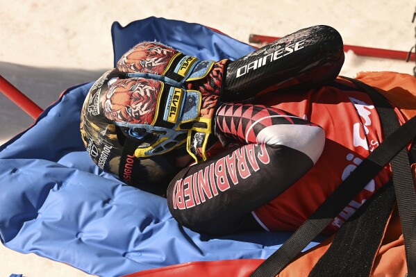 Overall World Cup skiing champion Italy's Federica Brignone is carried away on a toboga after she broke multiple bones in her left leg during a giant slalom crash at the Italian championships in the Lusia ski area, in Val di Fassa, Italy, Thursday, April 3, 2025. (AP Photo/Elvis Piazzi)
