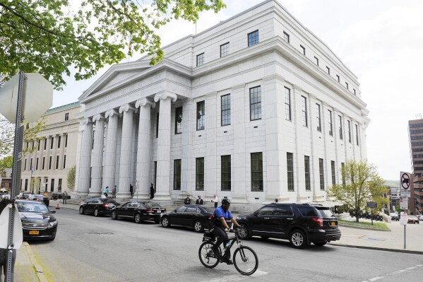 FILE - A Police cyclist rides past the New York Court of Appeals, May 5, 2015, in Albany, N.Y. New York's high court has upheld a rule requiring companies with health insurance plans to cover medically necessary abortions. The decision from the Court of Appeals on Tuesday, May 21, 2024, came after a lawsuit from the Roman Catholic Diocese of Albany and other religious groups that argued the rule violated their religious freedoms. (AP Photo/Hans Pennink, File)
