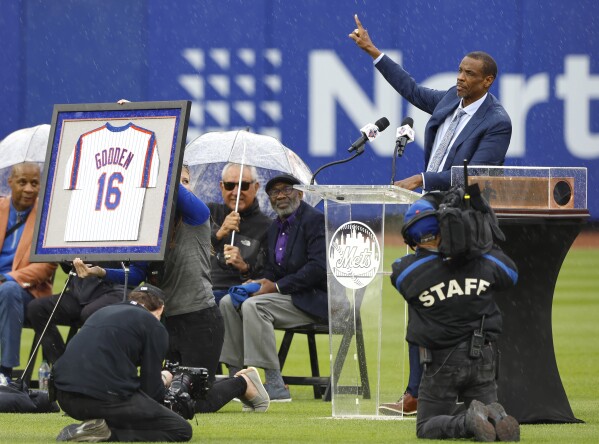 Former New York Mets pitcher Dwight Gooden, top right, acknowledges fans during a ceremony to retire his number at Citi Field before a baseball game between the Mets and the Kansas City Royals, Sunday, April 14, 2024, in New York. (AP Photo/Noah K. Murray)