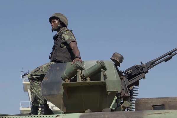 FILE - In this image made from video, a Mozambican soldier rides on an armored vehicle at the airport in Mocimboa da Praia, Cabo Delgado province, Mozambique, Aug. 9, 2021. Aid agencies and local authorities say a surge of new attacks by an Islamic State-affiliated group in northern Mozambique has left more than 70 children missing and caused 100,000 people to flee their homes. There are fears the children may have drowned in a river or been kidnapped by militants, the aids groups said in a report on Wednesday March 6, 2024. (AP Photo/Marc Hoogsteyns, File)