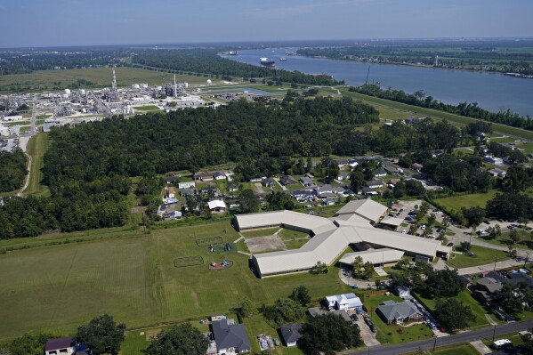 The Fifth Ward Elementary School and residential neighborhoods sit near the Denka Performance Elastomer Plant, back left, in Reserve, La., Sept. 23, 2022. (AP Photo/Gerald Herbert, File)