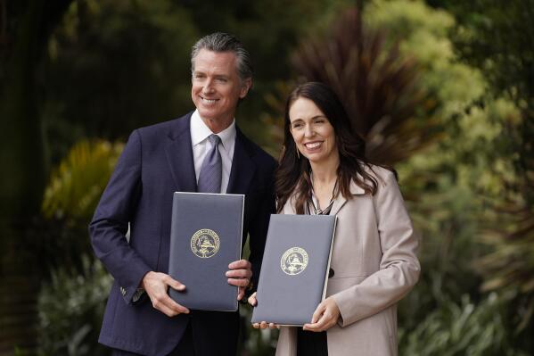 California Gov. Gavin Newsom and New Zealand Prime Minister Jacinda Ardern pose with agreements they signed at the San Francisco Botanical Garden in San Francisco, Friday, May 27, 2022.  Gov. Newsom met with Ardern in Golden Gate Park "to establish a new international partnership tackling climate change." (AP Photo/Eric Risberg)