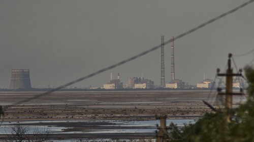 FILE - The Zaporizhzhia nuclear power plant, Europe's largest, is seen in the background of the shallow Kakhovka Reservoir after the dam collapse, in Energodar, Russian-occupied Ukraine, Tuesday, June 27, 2023. The U.N. atomic watchdog said in a statement late Monday, July 24, 2023, its staff at Ukraine’s Russian-occupied Zaporizhzhia Nuclear Power Plant report seeing anti-personnel mines around the site. The report comes as Kyiv pursues a counteroffensive against the Kremlin’s entrenched forces after 17 months of war. (AP Photo/Libkos, File)