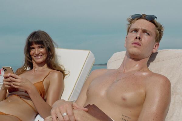 This image released by Neon shows Charlbi Dean Kriek, left, and Harris Dickinson in a scene from "Triangle of Sadness." (Neon via AP)