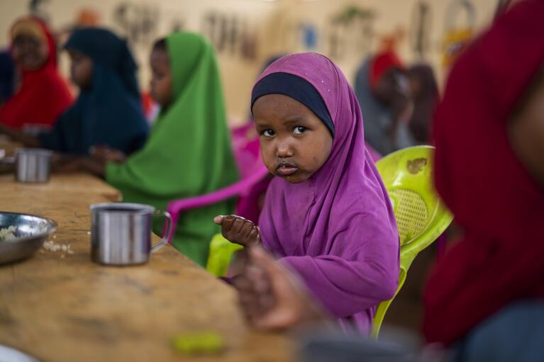 A child eats at a school in Dollow, Somalia, on Monday, Sept. 19, 2022. At midday, dozens of hungry children from the camps try to slip into a local primary school where the World Food Program offers a rare lunch program for students. (AP Photo/Jerome Delay)