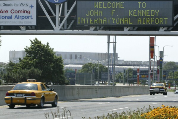 FILE - A taxi passes under the entrance to JFK Airport in the New York borough of Queens, Aug. 15, 2003. A cargo plane headed from New York's John F. Kennedy International Airport to Belgium had to return to JFK on Nov. 9, 2023, after a horse escaped its stall and got loose in the hold, according to air traffic control audio. (AP Photo/Stuart Ramson, File)