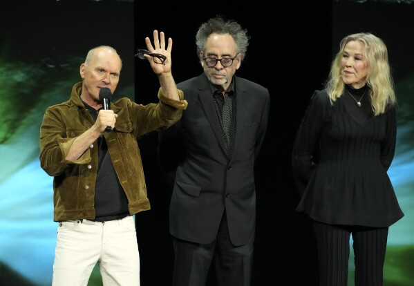 Michael Keaton, left, a cast member in the upcoming film "Beetlejuice Beetlejuice," discusses the film as director Tim Burton, center, and cast member Catherine O'Hara look on during the Warner Bros. Pictures presentation at CinemaCon 2024, Tuesday, April 9, 2024, in Las Vegas. (AP Photo/Chris Pizzello)