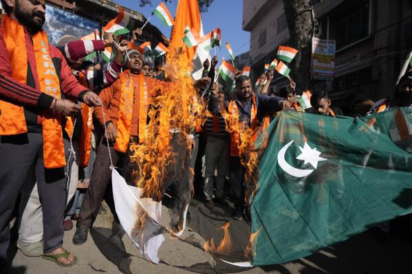 Activists of right wing Hindu groups Dogra Front and Shiv Sena, reacting to the militant attack in the southern Rajouri district of Indian-controlled Kashmir burn Pakistan flag during a protest in Jammu, India, Monday, Jan.2, 2023. Assailants sprayed bullets toward a row of civilian homes Sunday night, leaving at least four civilians dead and five others injured, police said Monday. (AP Photo/Channi Anand)