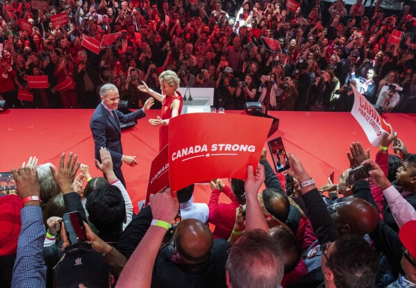Canadian Prime Minister Mark Carney and his wife Diana Fox Carney react on stage at his campaign headquarters after the Liberal Party won the Canadian election in Ottawa on Tuesday, April 29, 2025. (Frank Gunn/The Canadian Press via AP)