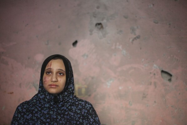 A Palestinian woman stands in her home after an Israeli strike in Rafah, Gaza Strip, Sunday, Dec. 24, 2023. (AP Photo/Hatem Ali)