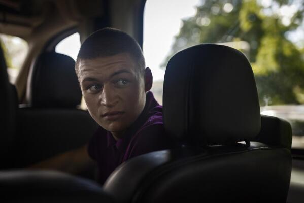 Timofey sits in a car in Loue, western France, Saturday, July 2, 2022. It took Timofey a couple of days before he could believe he was really back with his parents after being separated from them during the war. (AP Photo/Jeremias Gonzalez)