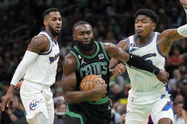 Boston Celtics guard Jaylen Brown, center, vies for control of the ball with Washington Wizards guard Monte Morris, left, and forward Rui Hachimura in the first half of an NBA basketball game, Sunday, Oct. 30, 2022, in Boston. (AP Photo/Steven Senne)