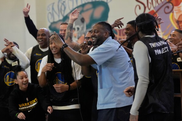 Ray Woodfork, a graduate of Twinning Project's collaboration with the NBA's Golden State Warriors and the California Department of Corrections and Rehabilitation's cohort 1, middle, performs a rap song in front of cohort 2 participants and Warriors Basketball Academy members at Solano State Prison in Vacaville, Calif., Tuesday, Feb. 11, 2025. (AP Photo/Jeff Chiu)