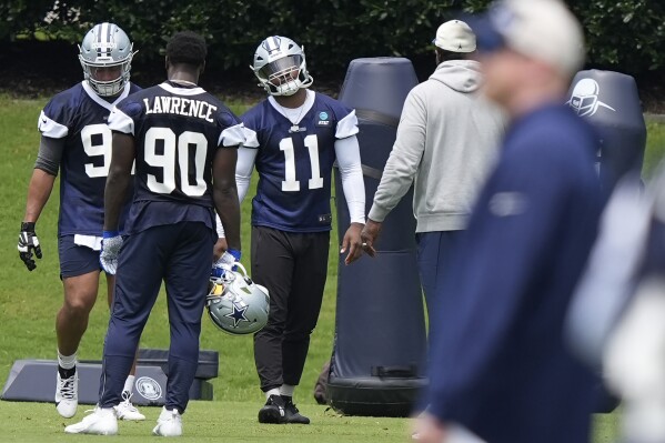 Dallas Cowboys linebacker Micah Parsons (11) stands with defensive end DeMarcus Lawrence (90) and other teammates during NFL football practice in Frisco, Texas, Wednesday, June 5, 2024. (AP Photo/LM Otero)