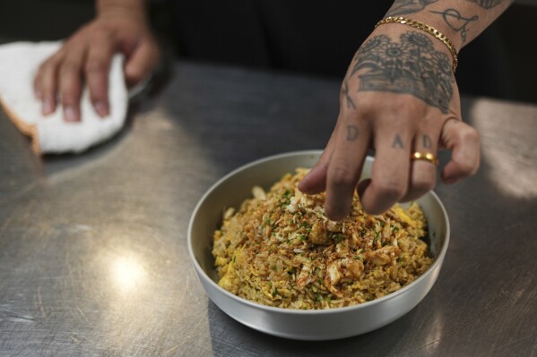 Chef Phila Lorn puts the final touches on a dish of The Thai Crab Fried Rice at the Mawn restaurant in Philadelphia, Thursday, May 22, 2025. (AP Photo/Matt Rourke)