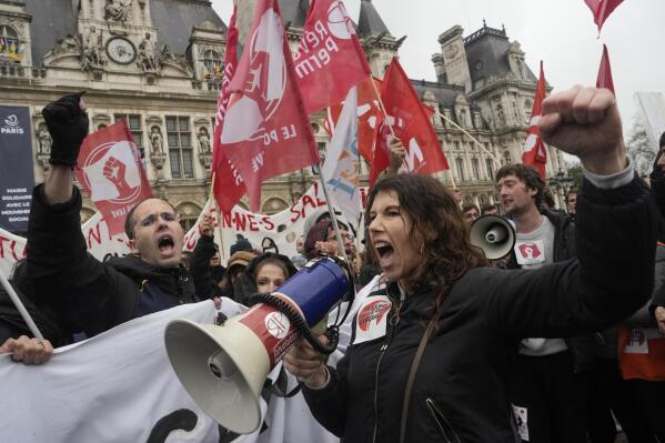 Demonstrate gather outside the Paris town hall, Friday, April 14, 2023 in Paris. France's Constitutional Council on Friday approved an unpopular plan to raise the retirement age to 64, in a victory for French President Emmanuel Macron after three months of mass protests over the legislation that have damaged his leadership. The move is likely to enrage unions and other opponents of the pension plan, including protesters gathered in spots around France on Friday evening as the decision came down.(AP Photo/Lewis Joly)