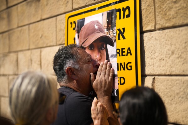 Eli Albag cries over the photograph of his daughter Liri, as he gathers with others during a protest demanding the release of dozens of Israelis who were abducted by Hamas during their unprecedented attack a week earlier, in Tel Aviv, Israel, Saturday, Oct. 14, 2023. (AP Photo/Francisco Seco)