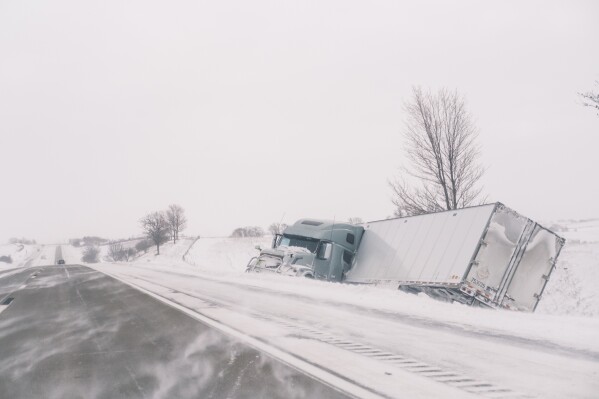An crashed semi truck sits abandoned along Interstate 80 in central Iowa on Saturday, Jan. 13, 2024. Heavy snow and high winds led the National weather service to issue a blizzard warning for much of the state of Iowa. (Nick Rohlman/The Gazette)/The Gazette via AP) /The Gazette via AP)