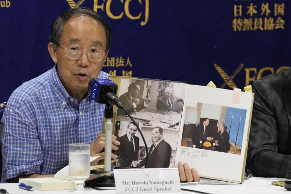 Legal expert Hiroshi Yamaguchi, holding a book related to the Unification Church, speaks during a news conference on the church and its activities at the Foreign Correspondents' Club of Japan in Tokyo, Friday, July 29, 2022. A group of lawyers said Friday that the alleged assassin of former Prime Minister Shinzo Abe was one of many victims of the Unification Church, which has long cultivated ties with high-level Japanese politicians. (AP Photo/Shuji Kajiyama)