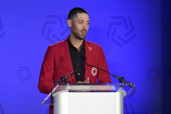 FILE - Clint Dempsey makes remarks during an induction ceremony for the United States National Soccer Hall of Fame, Sunday, May 22, 2022, in Frisco, Texas. Dempsey thinks the U.S. Soccer Federation hurt the men’s national team by delaying its decision on a coach leading up to the 2026 World Cup. (AP Photo/Tony Gutierrez, File)