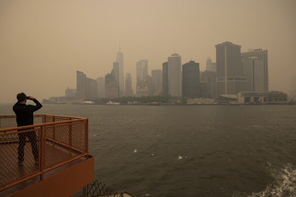FILE - New York City is seen in a haze-filled sky, photographed from Staten Island Ferry, June 7, 2023, in New York. At about summer's halfway point, the record-breaking heat and weather extremes are both unprecedented and unsurprising, hellish yet boring in some ways, scientists say. (AP Photo/Yuki Iwamura, File)