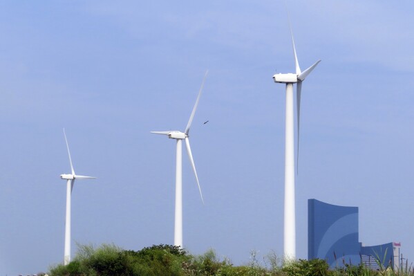 FILE - Land-based wind turbines in Atlantic City, N.J., turn on July 20, 2023. Two major offshore wind power projects are taking steps forward in New Jersey as the owners of one project agreed to bring the federal government in on their environmental monitoring plans at an earlier stage than has ever been done, and federal regulators said plans for another project are not expected to kill or seriously injure marine life. They come as New Jersey continues to grow as a hub of opposition to offshore wind projects from residents' groups and their political allies, mostly Republicans. (AP Photo/Wayne Parry, File)