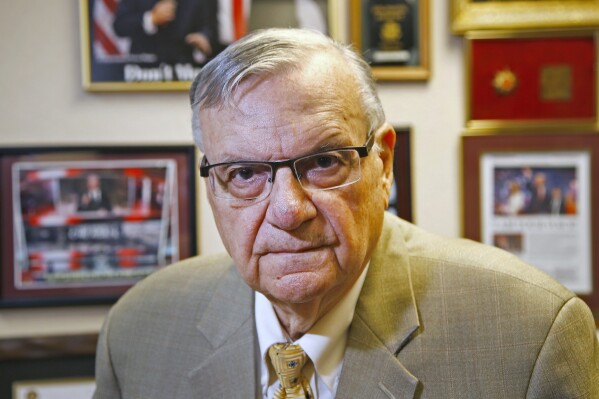 FILE - In this Aug. 26, 2019, file photo, former Maricopa County Sheriff Joe Arpaio poses at his private office in Fountain Hills, Ariz. On Monday, May 20, 2024, county officials said legal and compliance costs in a racial profiling lawsuit over Arpaio’s immigration crackdowns are expected to reach $314 million by mid-summer of 2025. In 2013, a federal judge concluded the Maricopa County Sheriff’s Office had profiled Latinos in Arpaio’s signature traffic patrols that targeted immigrants, leading to massive court-ordered overhauls of both the agency’s traffic operations and its internal affairs department. (AP Photo/Ross D. Franklin, File)