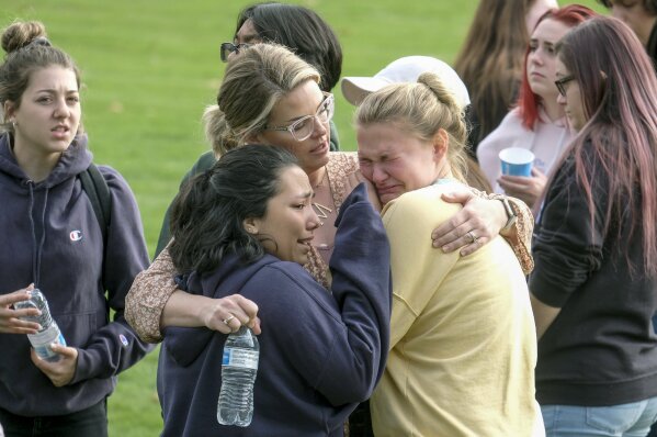 Students are comforted as they wait to be reunited with their parents following a shooting at Saugus High School that injured several people, Thursday, Nov. 14, 2019, in Santa Clarita, Calif. (AP Photo/Ringo H.W. Chiu)
