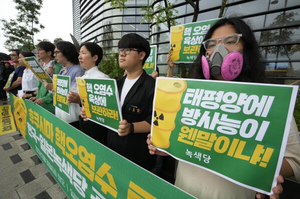 Environmental activists protest against the Japanese government's decision to release treated radioactive wastewater from the wrecked Fukushima nuclear power plant, near a building which houses the Japanese Embassy in Seoul, South Korea, Friday, June 30, 2023. The letters read, "Radioactive water in ground facilities." (AP Photo/Ahn Young-joon)